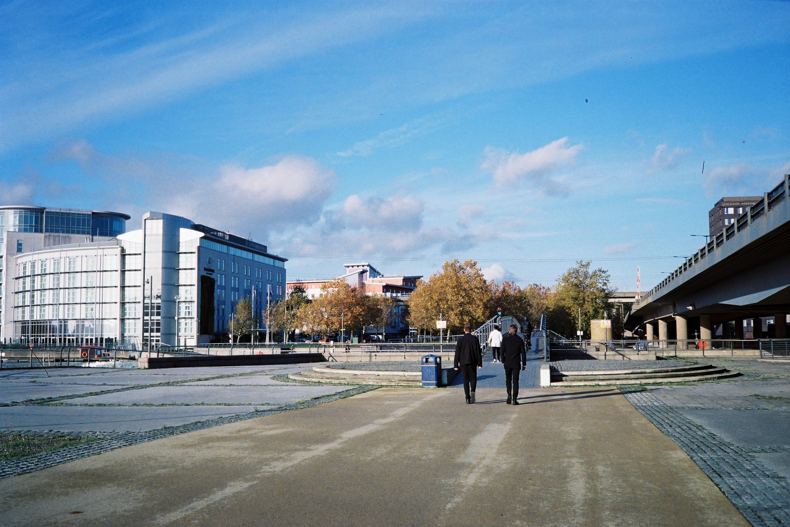 Two figures walking near Canary Wharf